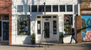 Man walks in front of Neighborly Book Store at sunset.